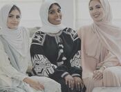 Picture of three young smiling women wearing scarves; hijabs; 
