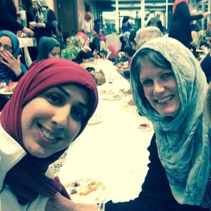 Picture of two smiling women wearning head scarf/hijabiling and talkinga 